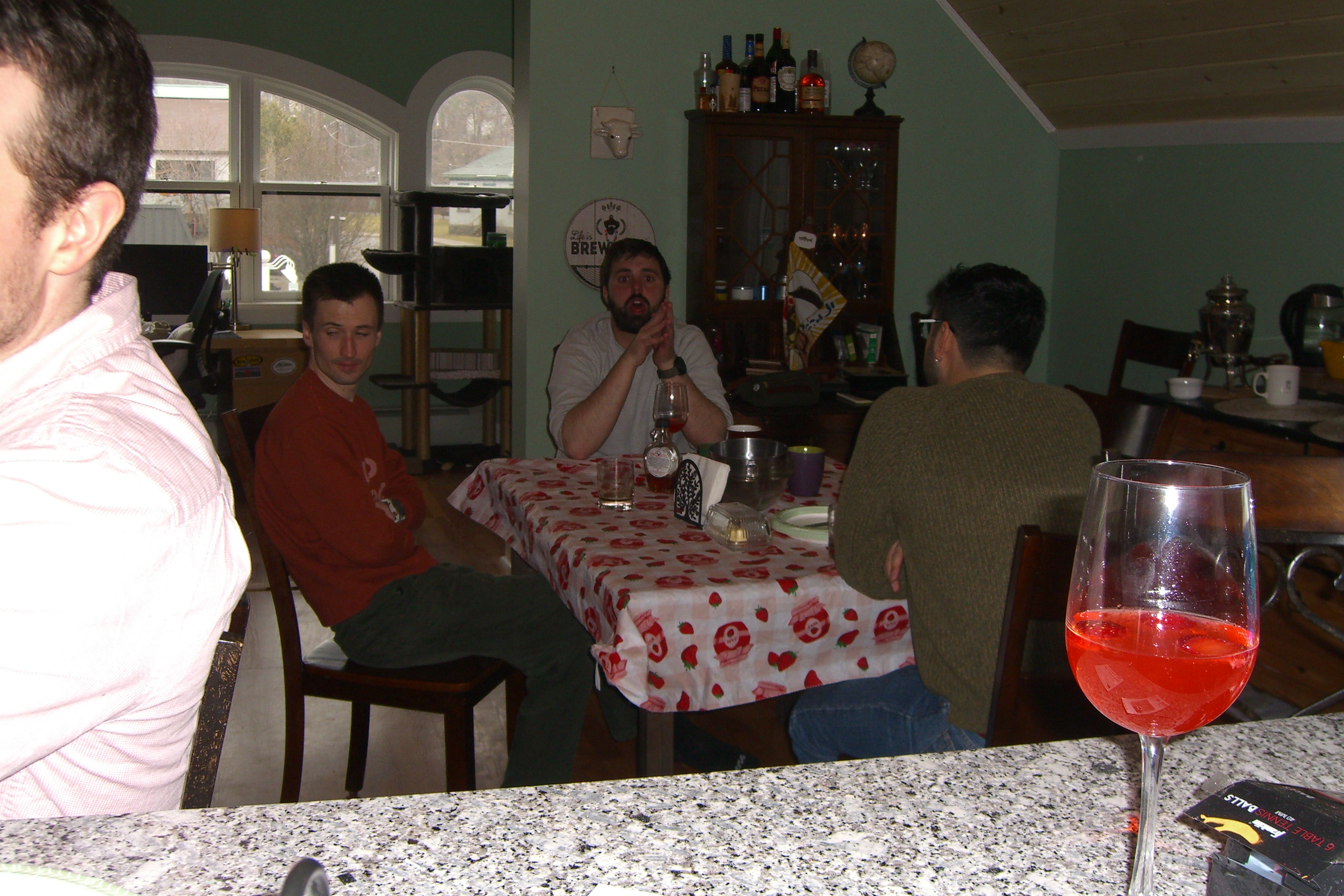 Four people sitting around a dining table with drinks