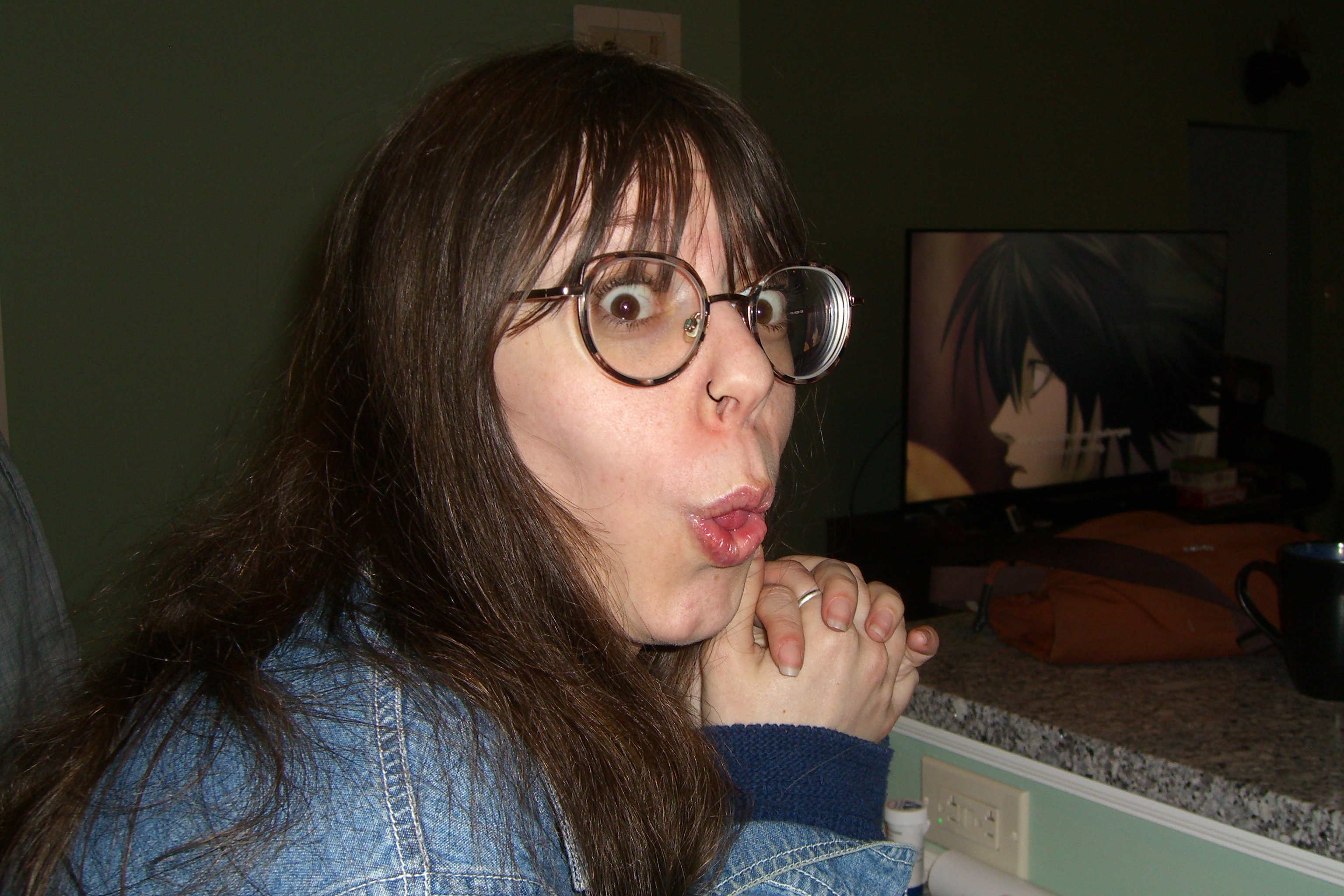 Woman making exaggerated surprised face with anime on TV