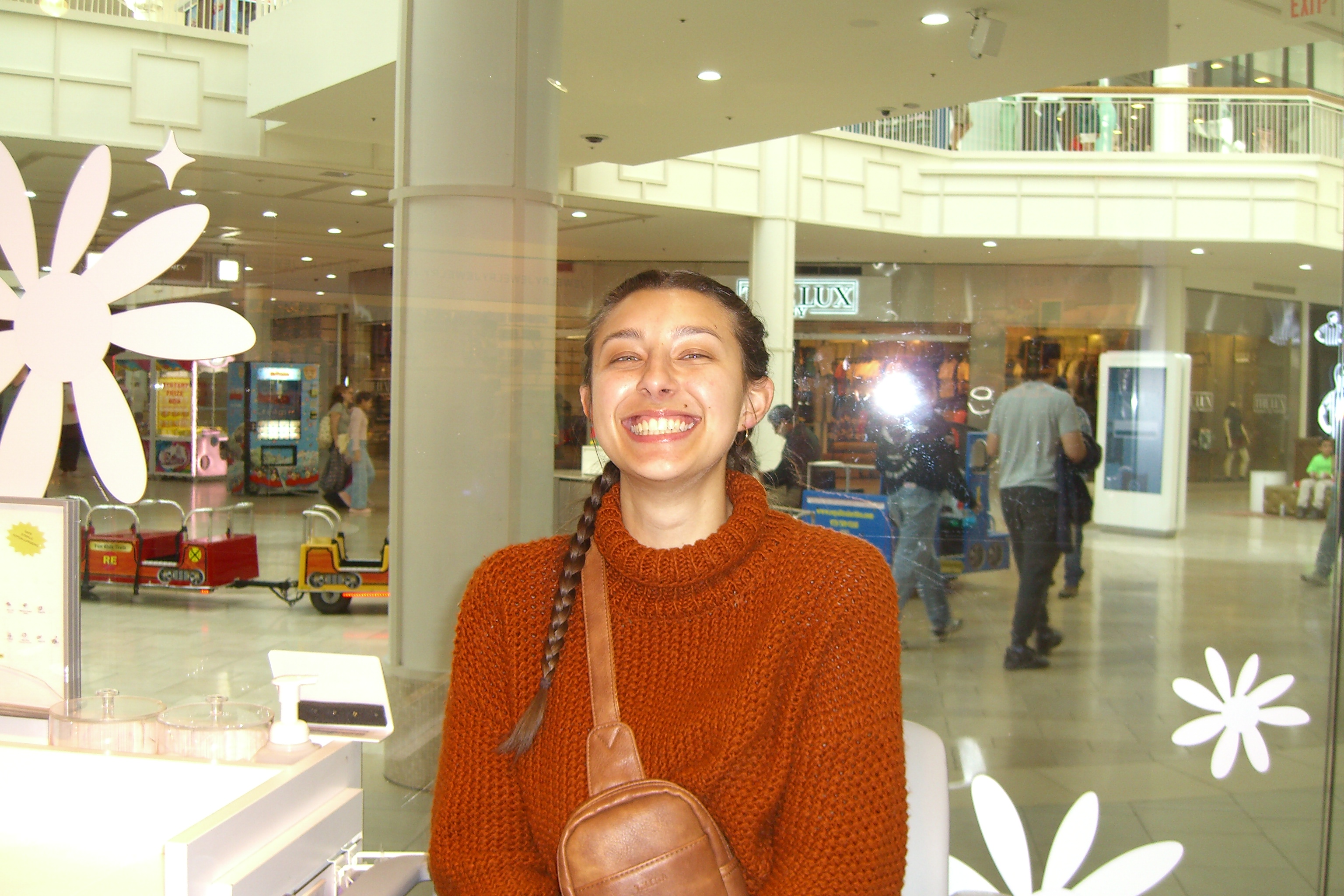 Woman laughing in a rust sweater at the mall